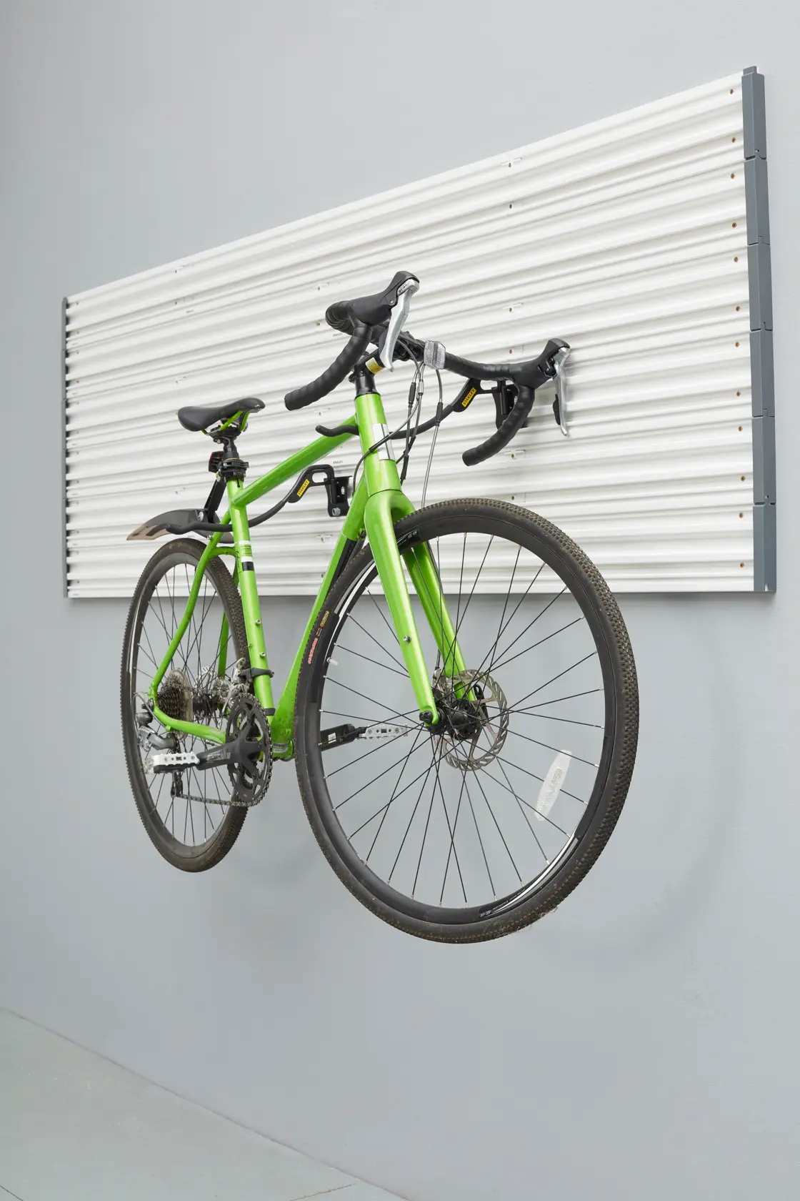 STANLEY STST82615-1 Wandpaneel mit hängendem grünem Fahrrad, seitliche Aufnahme.