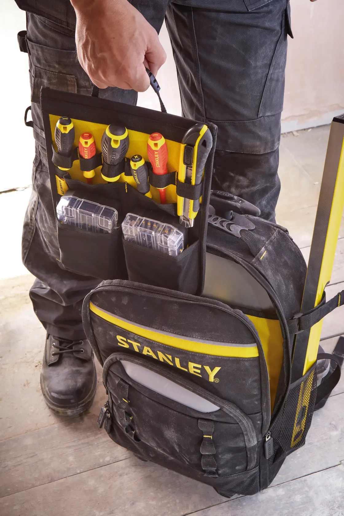 STANLEY STST83307-1 Werkzeugrucksack mit gelb-roten Handwerkzeugen und Boxen in der Fronttasche.